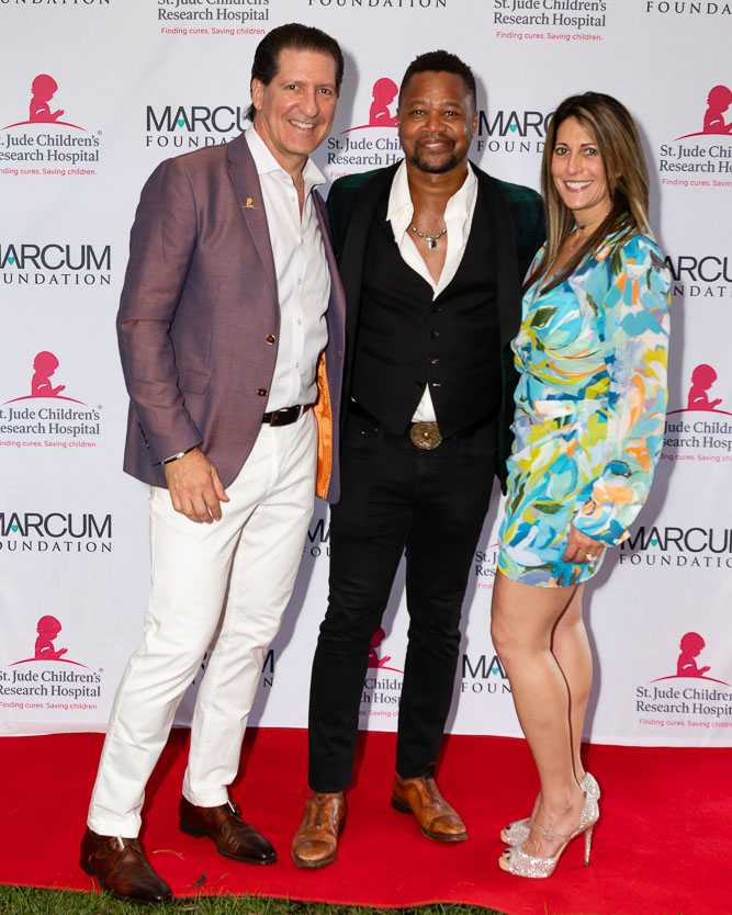 Two men and a woman in front of a step-and-repeat background