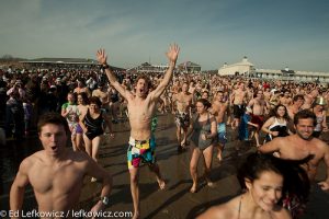 A crowd runs to the water for the January 1st Polar Bear plunge in Narragansett, RI