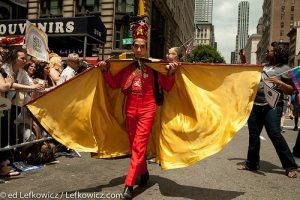 A man in a red suit and a cape with a bright yellow lining, New York Pride Parade