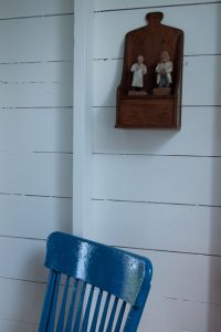 A blue chair and wall decor in a summer cottage, Sakonnet Point, Little Compton, Rhode Island.