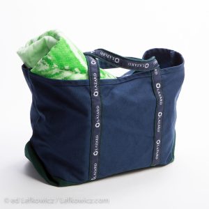 A blue canvas tote bag stuffed with toewels