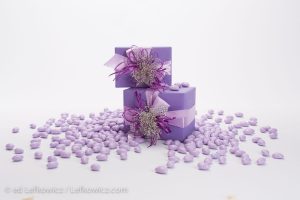 A stack of purple gift boxes in a spill of purple jellybeans