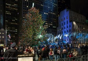 Tourists gather around the Christmas tree at Rockefeller Center at night