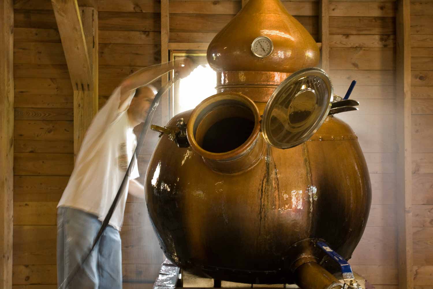 Keith Bodine, of Sweetgrass Winery and Distillery, cleaning his pot still.