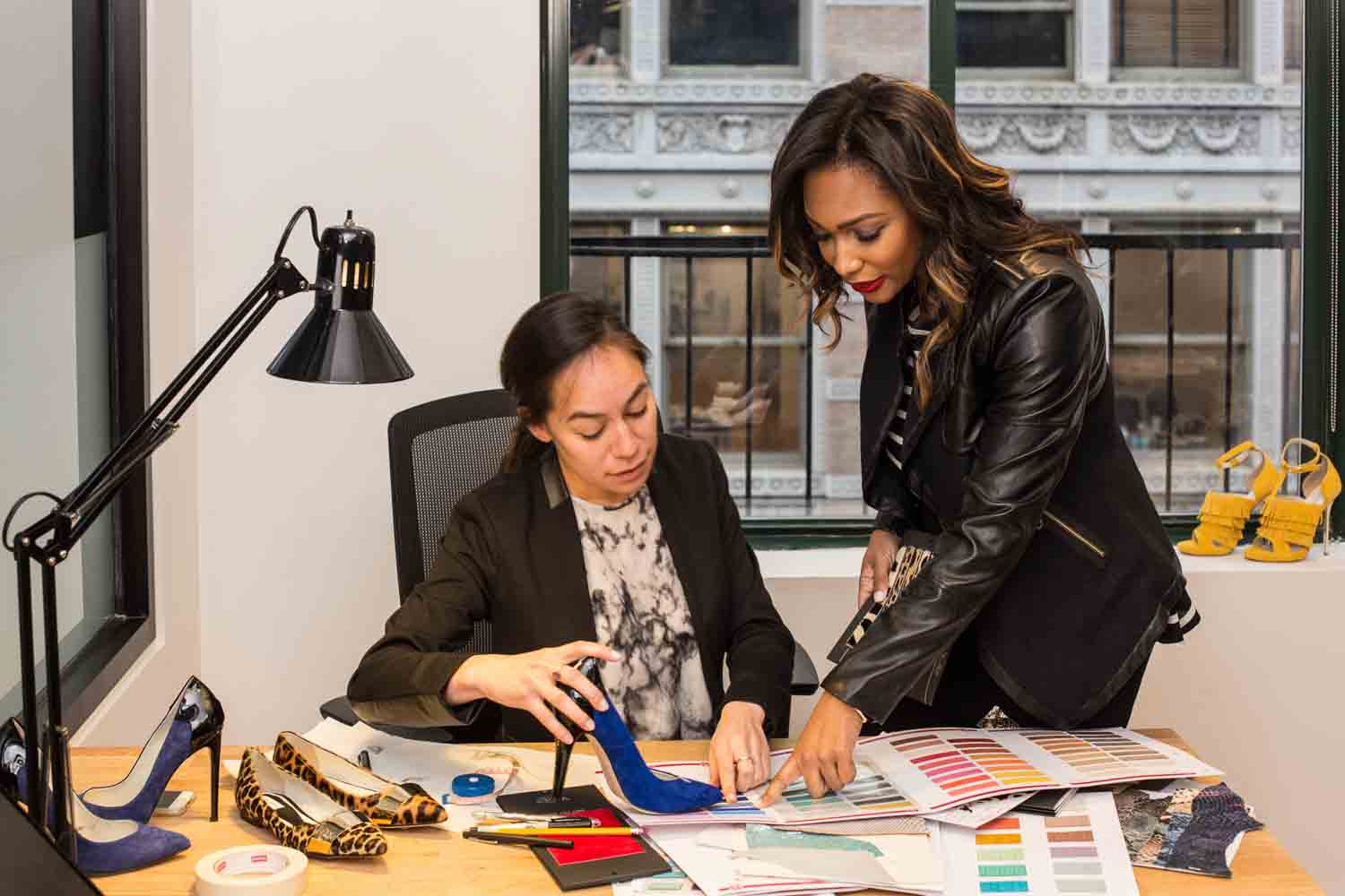A shoe designer and her assistant at work in an office