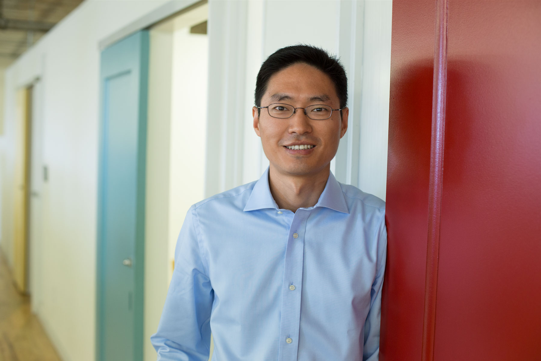 Branding photo of an Asian man in a colorful office environment