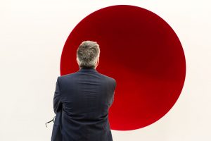 A man looks at Anish Kapoor's fiberglass and pigment "Void," 1990, in the Lisson Gallery at the 2017 Frieze Art Fair.