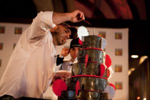 Baker Duff Goldman puts the finishing touches on an elaborate tiered cake at a gala for Best Buddies.