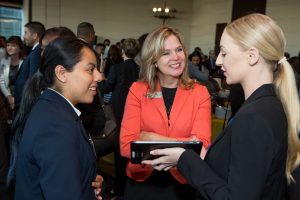 Two students discuss a project to an adult at an event for the National Academy Foundation.