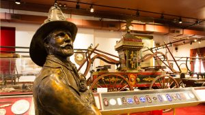 Bronze sculpture of a fireman carrying a child on front of a 19th-century fire engine Inside the New York City Fire Museum