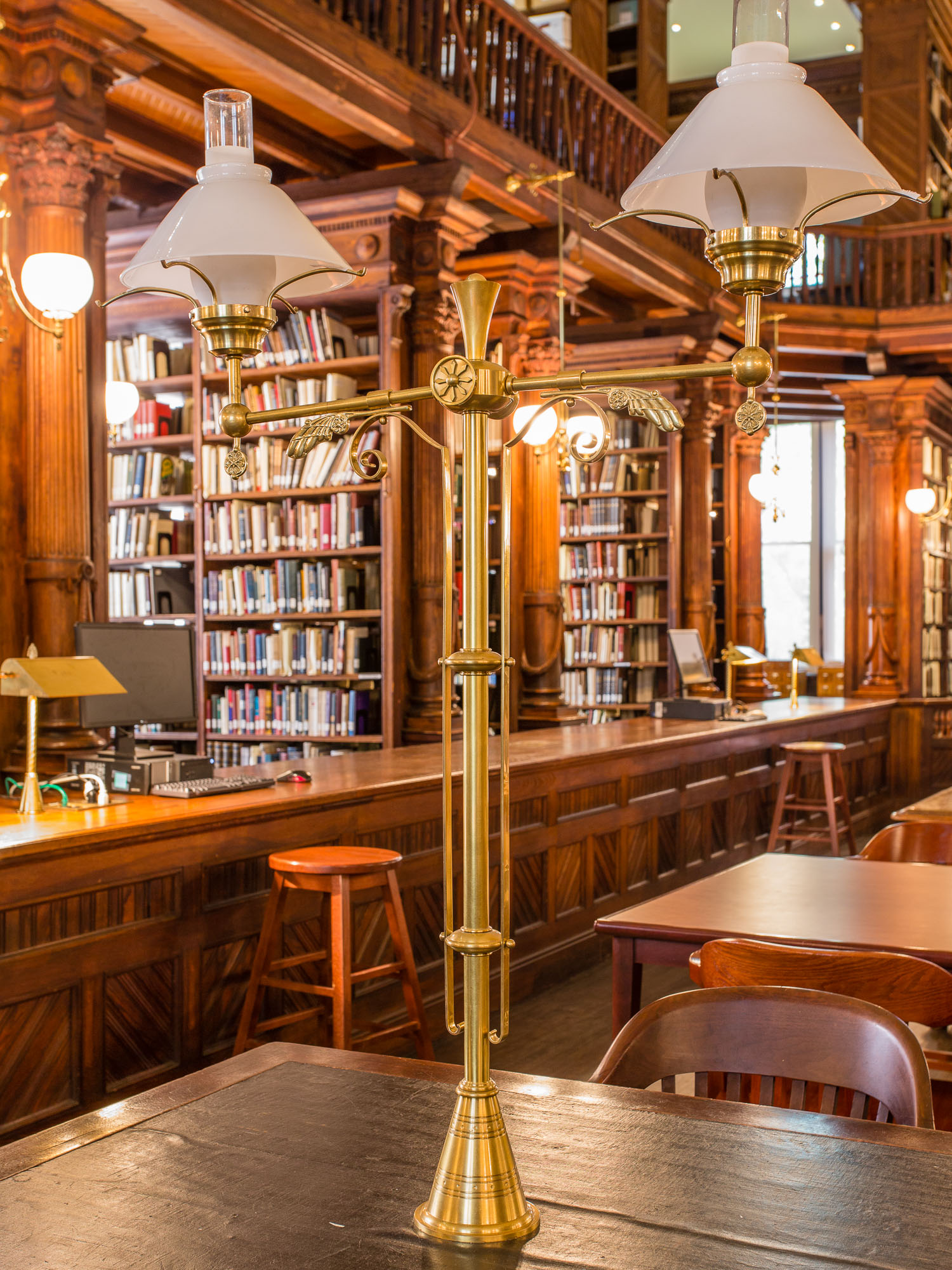 The reading room of the Brooklyn Historical Society with ornate brass lamps and carved woodwork.