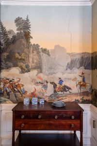 The dining room of the Fraunces Tavern Museum, with wallpaper by Zuber & Cie., showing battle scenes from the American Revolution.