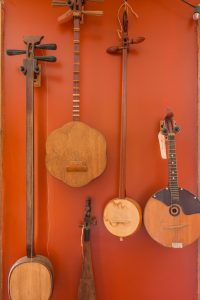 Unusual stringed instruments hang on a red wall at the Jalopy Theatre and School of Music.