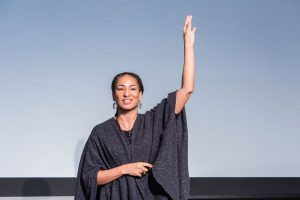 Ruha Benjamin on stage with her arm raised, for the Toigo Foundation