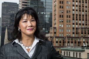 Executive portrait of an Asian woman with city buildings in the background