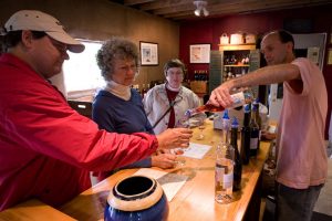 Winemaker pouring samples at a winery tasking bar