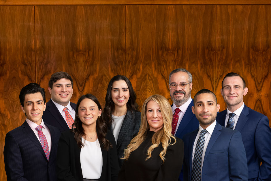 Corporate group against a bookmatched wood panel background