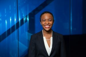 Executive portrait of a smiling Black woman against an abstract backlit blue background