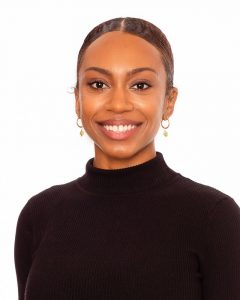 Headshot of a smiling young Black woman against a white background