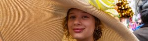 photo of a woman's face under a very wide straw hat