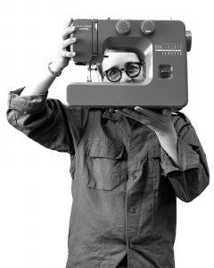 Woman looking from behind a sewing machine